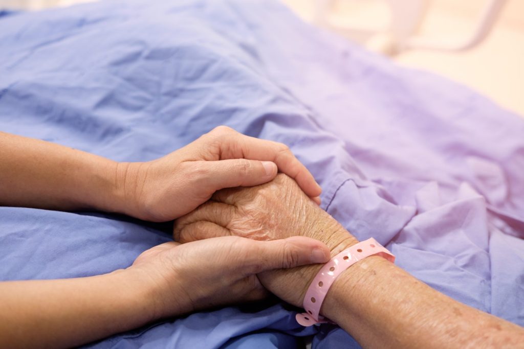 photo of elderly person's hand holding hands with younger person as it relates to disability claims